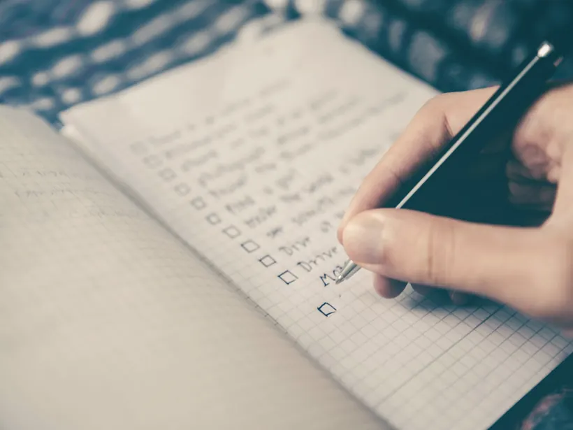 A hand writing by hand in an open notebook